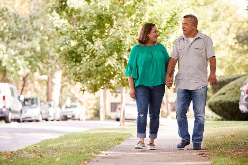 A couple stroll down a suburban street