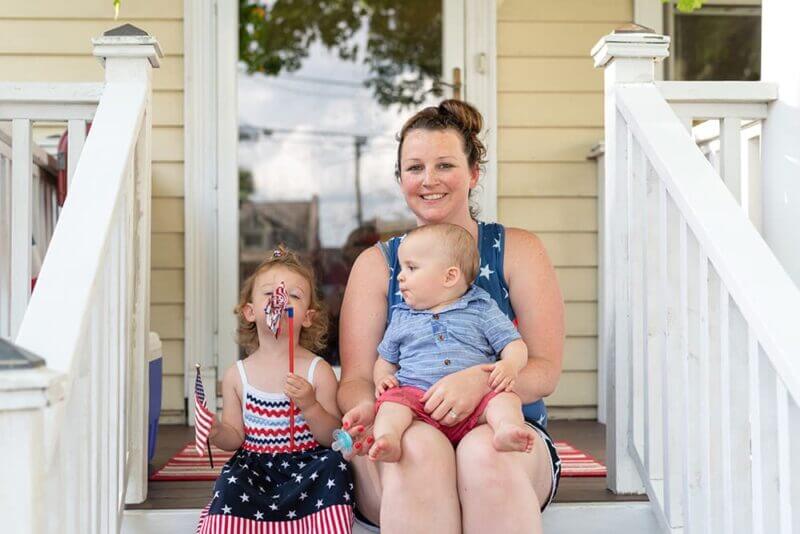 Mother and her two children on the porch of their home