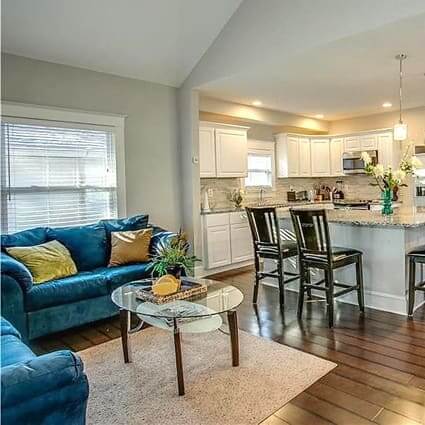 View of a contemporary great room with blue sofas and a modern kitchen