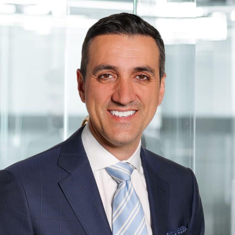 Portrait of a smiling executive man wearing a dark blue coat and a blue striped tie