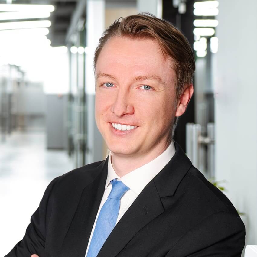 Portrait of a young man in a dark coat and a blue tie