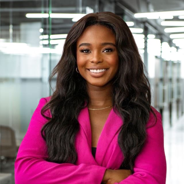 Smiling woman with long dark hair in a fuscia blazer